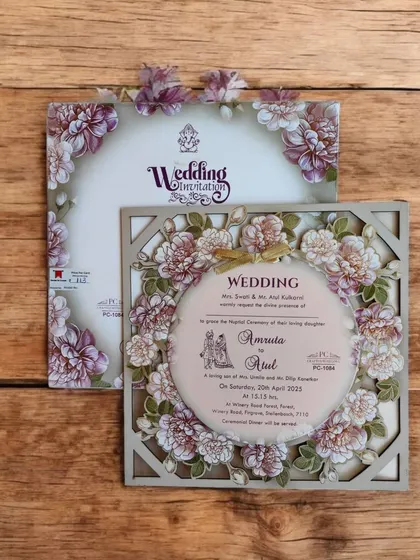 A square MDF laser-cut invitation with a circular floral frame. The purple and pink flowers add a pop of color to the elegant design.