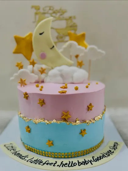 A dreamy "Twinkle Twinkle Little Star" themed baby shower cake. This pink and blue cake features a sleeping moon, fondant stars, and a sweet message for the baby.