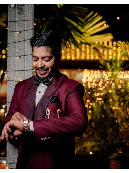 A candid shot of the groom smiling while checking his watch before the reception.