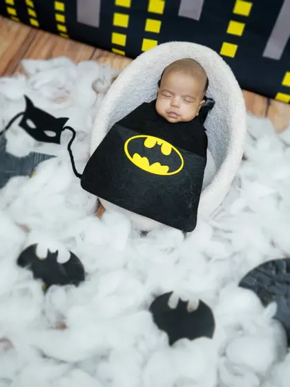 An overhead shot of the 'Little Batman' peacefully sleeping, surrounded by the props and backdrop of his miniature Gotham.