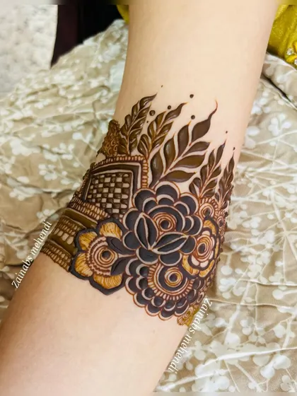 A close-up of a bridal armband for Maryam, featuring a bold rose and leaf design.