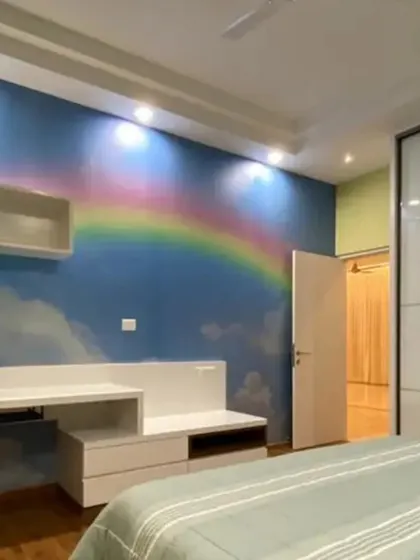 A dreamy bedroom scene with a custom rainbow and clouds mural, creating a cheerful and inspiring space for a child.