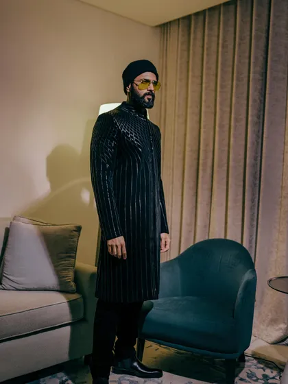 The full-length view of Vijay Deverakonda's outfit. The structured jacket paired with simple black trousers keeps the focus on the incredible design.