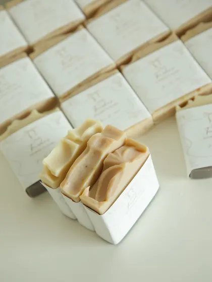 Two handmade soaps nestled in a custom box, part of a larger baby shower favor order.