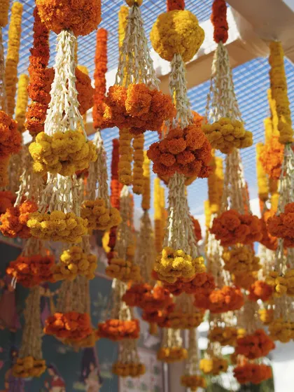 A close-up of the hanging floral strings, showing the craftsmanship of the traditional marigold and tuberose garlands.