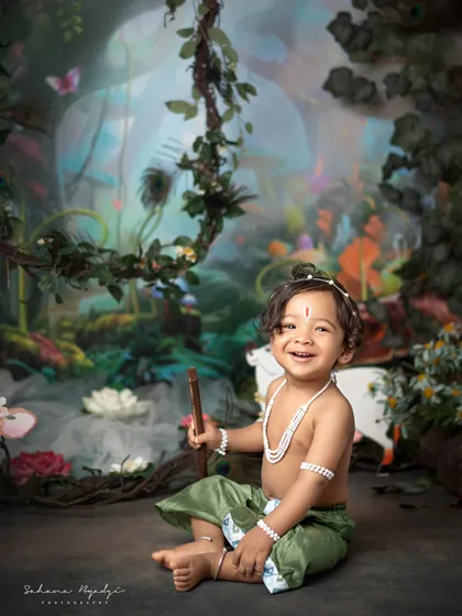 The bright smile of a little boy dressed as Krishna, sitting in our magical forest set. The colorful background and his happy energy make this a truly lively portrait.
