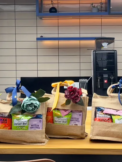 A lineup of jute bag snack hampers on an office pantry counter, ready for an employee event.