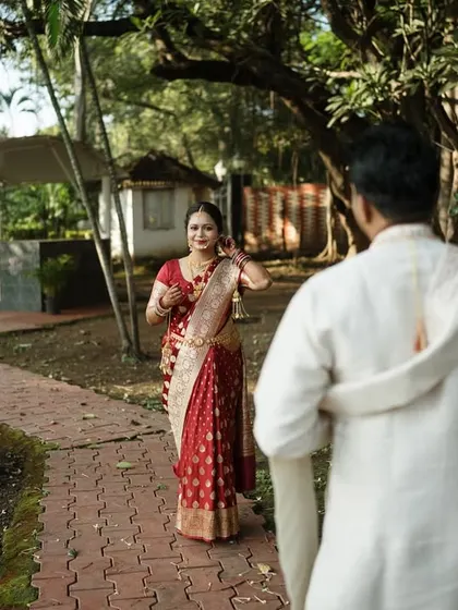 The "first look" moment. The groom's back is to the camera as he sees his bride for the first time, a composition that builds anticipation and focuses on her reaction.
