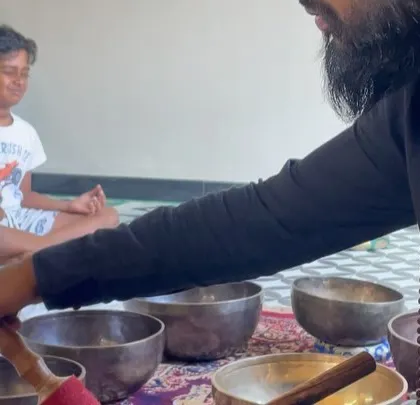Introducing a young participant to the sound of a singing bowl.
