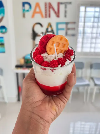 A delicious-looking dessert candle creation, topped with a wax waffle, raspberries, and cream.
