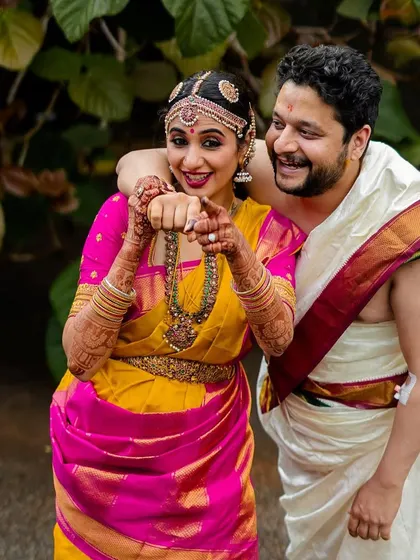 A playful and happy portrait of a couple in traditional South Indian wedding attire. Their vibrant energy and smiles are what make this shot so special.