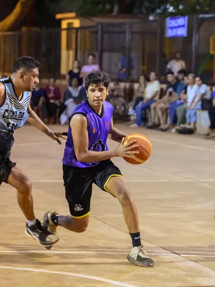 A player from the men's division drives hard to the basket, showcasing his ball-handling skills and determination.