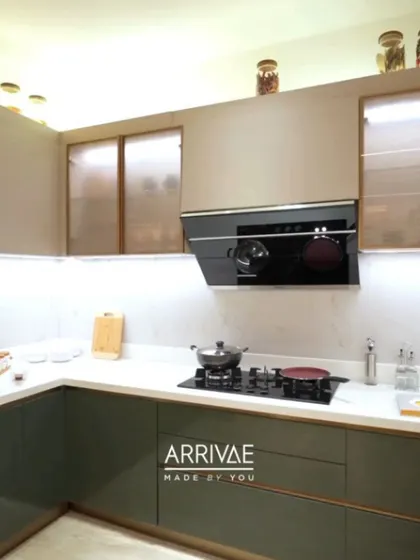 This two-tone kitchen in olive green and beige is both trendy and timeless. The frosted glass cabinets add a touch of elegance while keeping the contents partially hidden.