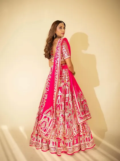 A back profile showcasing the full effect of the stunning gota patti lehenga. The hair was styled in soft waves to complement the traditional yet modern feel of the entire look.