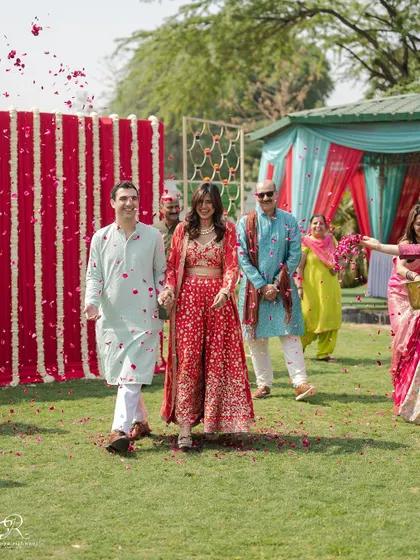 The happy couple being showered with rose petals as they make their entrance at their intimate Mehendi ceremony in Delhi.