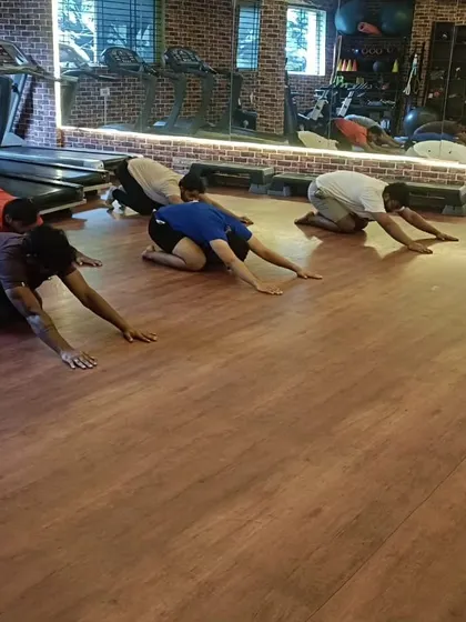 The class takes a moment in Balasana, or child's pose, a restorative posture used to gently stretch the back and hips.