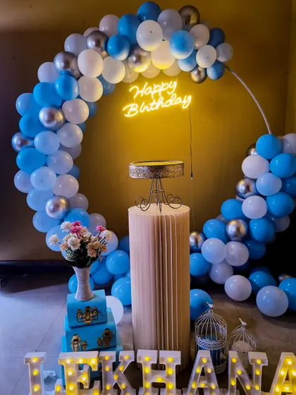 A clean and simple birthday setup with a blue, white, and silver balloon arch.