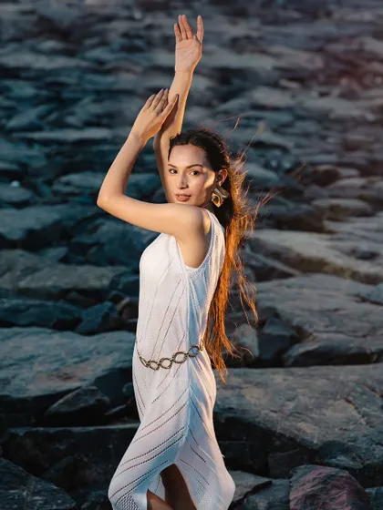 The full look in a beautiful outdoor setting. The wind-blown hair and natural makeup create a sense of freedom and effortless beauty.