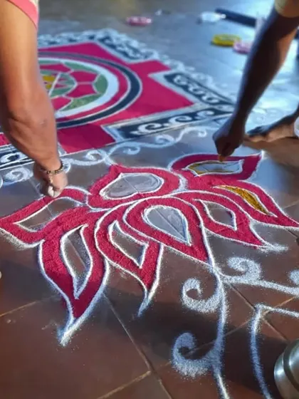 Close-up of the detailed line work in the rangoli. The precision and focus required are a practice in concentration.
