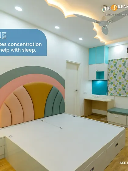 This bedroom uses a calming blue palette, which is known to promote concentration and sleep. The rainbow-themed headboard adds a playful and colorful touch to the serene space.