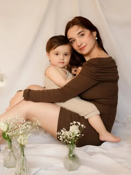 A calm and loving portrait. The mother holds her son securely, both looking at the camera, creating a classic and heartfelt image of their bond.