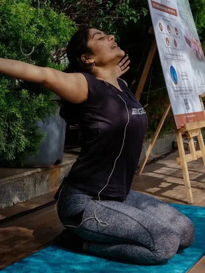 Leading a group through a heart-opening stretch during an outdoor wellness event. I guide participants to connect with their breath and body, leaving them feeling refreshed and open.