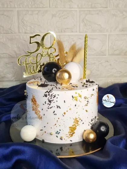 A popular design for milestone birthdays like 50th or 60th. This cake uses a palette knife technique with black, white, and gold, topped with dried botanicals for a rustic yet modern feel.