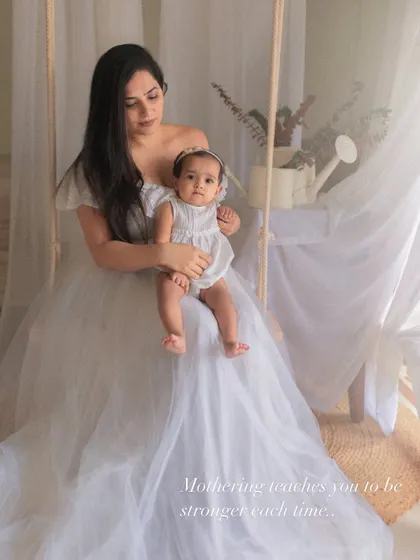"Mothering teaches you to be stronger each time." A quiet portrait of a mother holding her child, reflecting on the profound journey of motherhood.