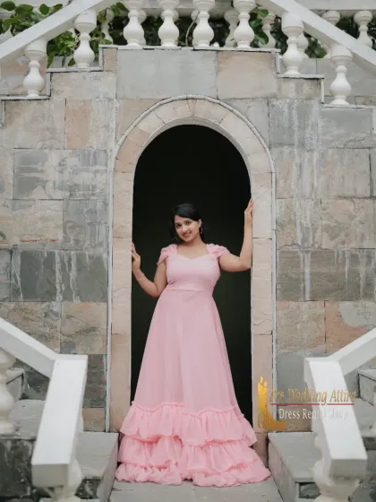 The pink ruffled ball gown framed in a stone archway. This setting enhances the fairytale quality of the dress.