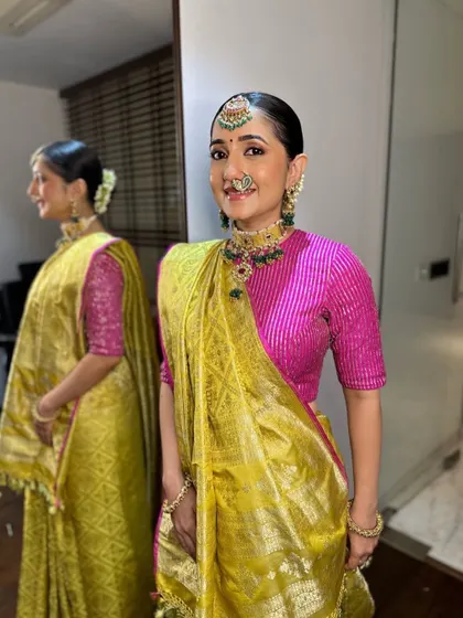A full-length view showing the beautiful drape of her Banarasi saree and her reflection, highlighting the sleek, traditional bun.