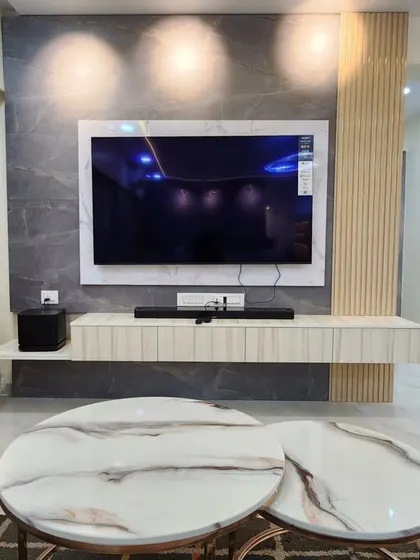 A close-up of the floating TV console and marble-topped nesting coffee tables from a recently completed project.