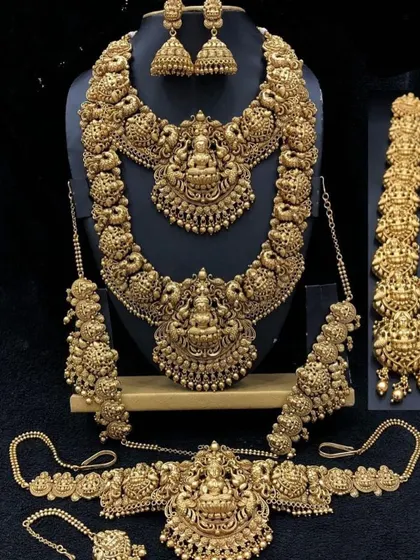 A full antique-finish temple jewellery set, perfect for achieving a classic bridal look. The set includes a choker, a long haaram, matching jhumkas, a vaddanam (waist belt), and hair accessories.