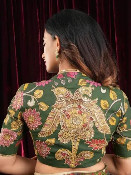 A full view of the green Kalamkari blouse with the stunning peacock back design, showing how it pairs beautifully with a simple cream saree.