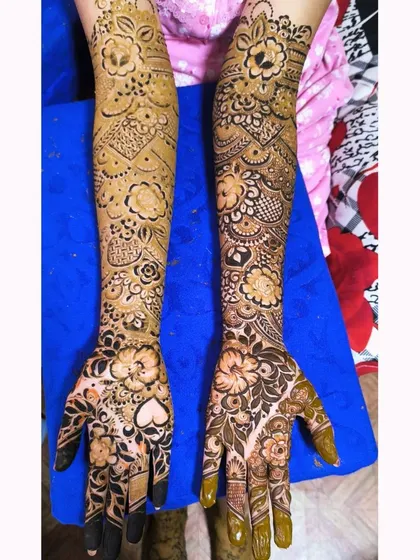 An asymmetrical design where one arm features a flowing floral vine and the other has more dense, traditional patterns.