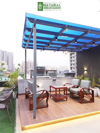 The completed seating area under a pergola with a blue-tinted roof at the Sushant Lok project.