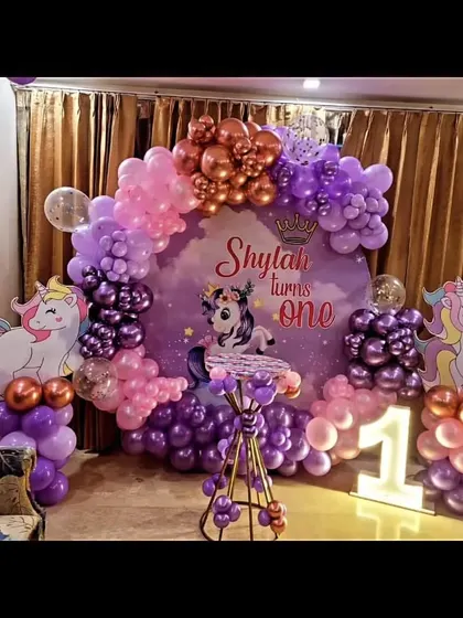 A magical unicorn-themed first birthday party for Shylah. I used shades of purple and pink for the balloon arch and included unicorn cutouts, a custom backdrop, and a light-up number '1'.