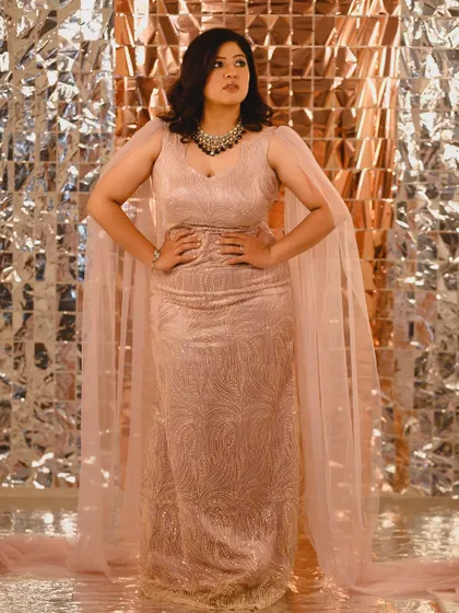 Meghana looking powerful and poised. This full-length shot shows off her stunning gown, and the makeup was created to complement its modern, elegant design.