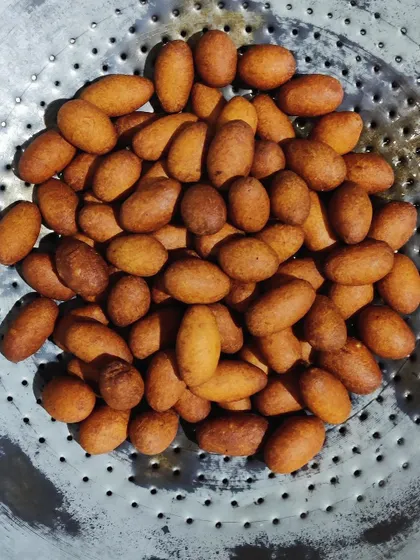 Freshly fried Jamuns, golden brown and ready to be soaked in sugar syrup. We prepare them in small batches to ensure each one is perfectly cooked.