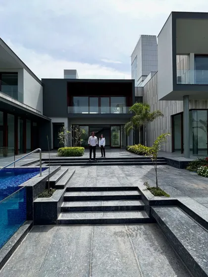 Standing in the central courtyard of Rosewood Farmhouse, our founders are framed by the home's symmetrical wings and the stunning pool. This space is the heart of the project, connecting all elements of the design.