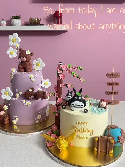 A tale of two themes. On the left, a lavender cake with sleeping teddy bears and daisies. On the right, a Totoro-themed cake for a travel lover. This shows the range of custom art I love to create.