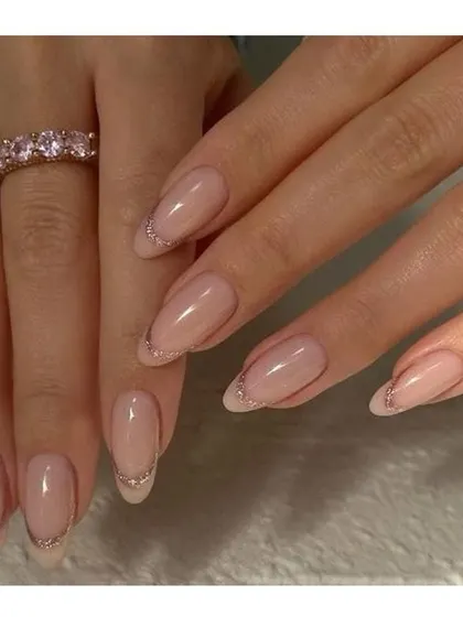 The definition of elegance. These long, almond-shaped nails have a natural sheer base with a very thin, subtle silver glitter line along the tip.