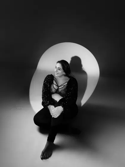 A sweet and happy moment captured in the studio. This black and white portrait uses creative lighting to highlight the joy and anticipation of a glowing mother-to-be.