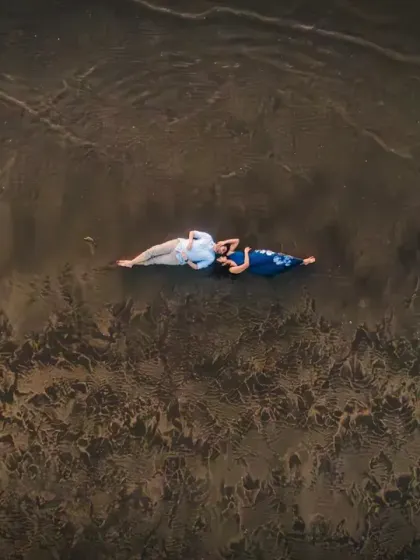 From above, we see a story of quiet connection. Lying on the wet sand as the waves retreat, this aerial view captures a serene, intimate moment, showing that love can be a peaceful escape from the world.