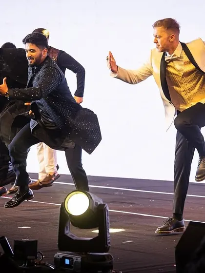 The groomsmen showing off their high-energy, synchronized jumps during their sangeet act.