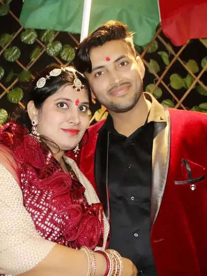 A couple dressed in festive red outfits for a celebration.