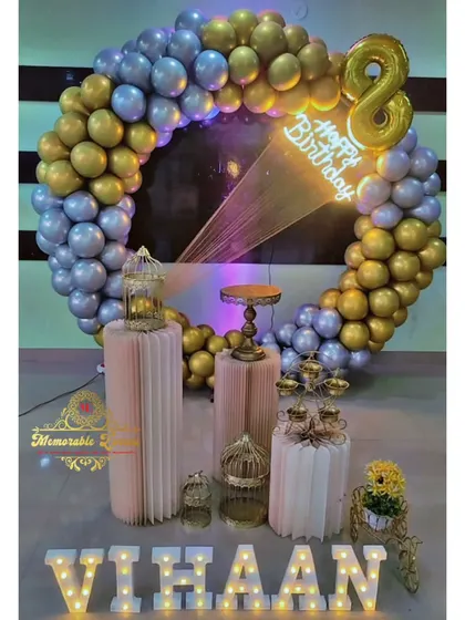 An 8th birthday party setup with a gold and silver balloon ring and a large foil number '8'.