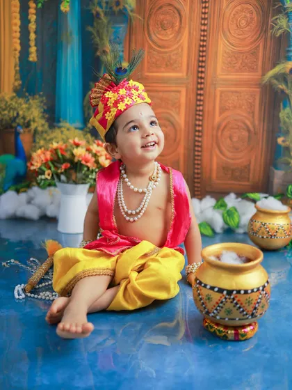 Looking up as if listening to a divine melody. This pose captures the serene and innocent side of Bal Gopal, surrounded by a beautifully crafted backdrop that evokes the feel of Vrindavan.