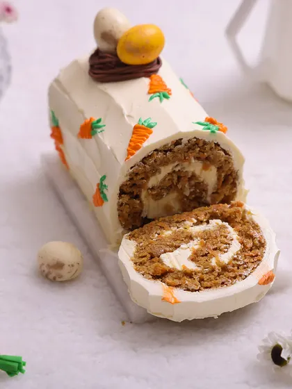 We put a twist on a classic with our Easter carrot roll cake. This delicious roll is filled with cream cheese frosting and decorated with tiny piped carrots and a chocolate nest, offering a unique and elegant alternative for your Easter dessert table.
