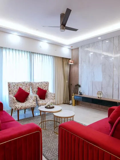Designing Palak and Ashwani’s home was about creating a welcoming space. In the living room, I used bold red velvet sofas and floral accent chairs to make it cozy and inviting.