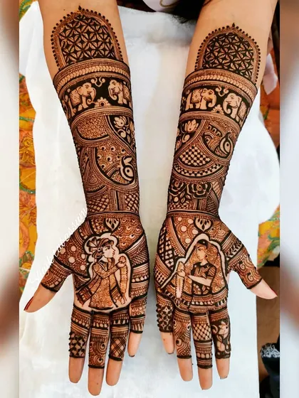 This design features individual portraits of the bride and groom, each framed beautifully on the palms. The forearms are adorned with traditional elephant motifs and intricate jaali (lattice) work.